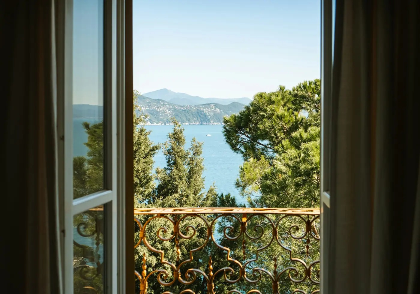 Otvoren balkon sa kovanom ogradom i pogledom na more i borove
